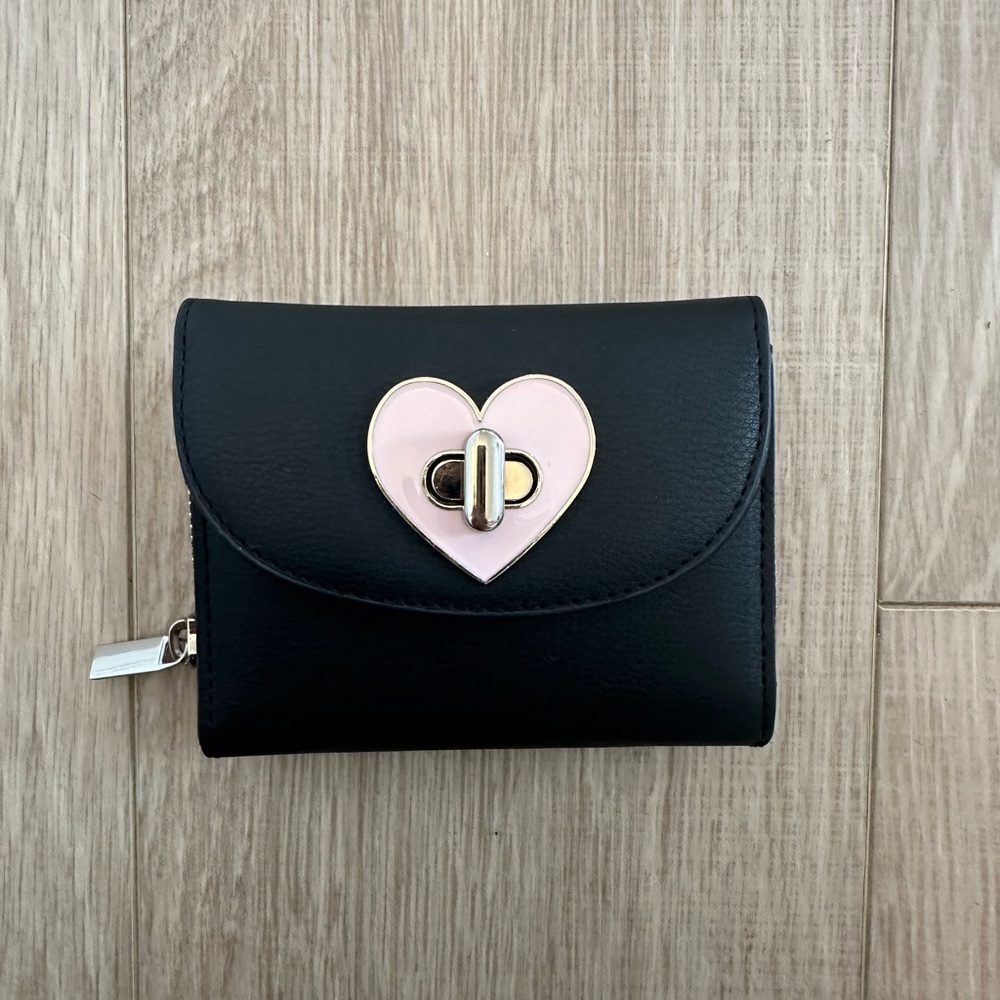 Black wallet with pink latch.